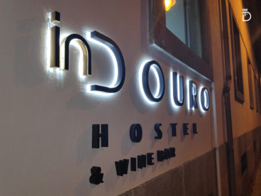 Indouro Hostel e Winebar reclamo com letras retro iluminadas